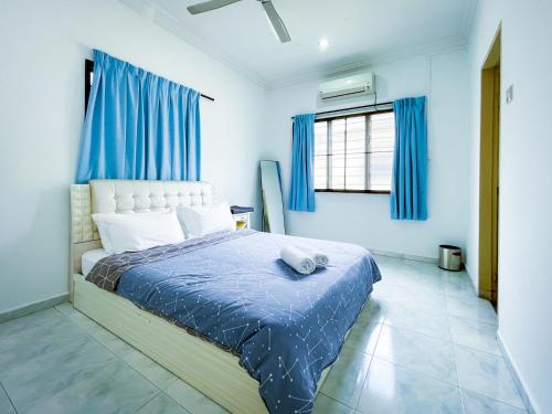 太平的住宿－Tupai Mas Semi-D by LOUIS，一间卧室配有一张蓝色墙壁和蓝色窗帘的床