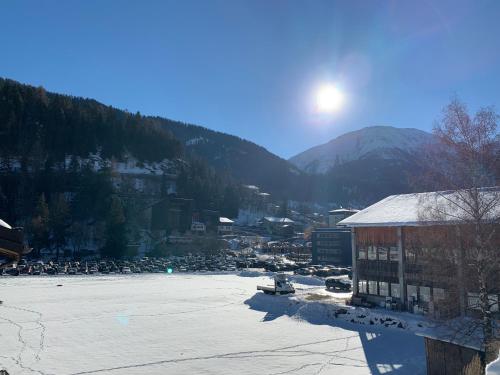 a snow covered town with a river and a mountain at Ferienwohnung - 100m von der Talstation Aletsch Bahnen und Bahnhof Fiesch, BESTE Ausgangslage in Fiesch