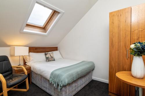 ein kleines Schlafzimmer mit einem Bett und einem Fenster in der Unterkunft Spacious 5-Bedroom Townhouse in the West-End in Aberdeen