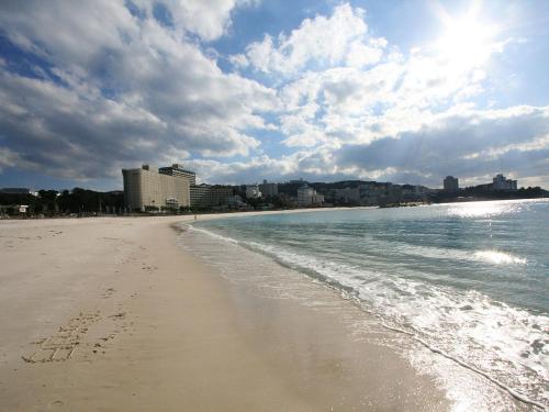 a beach with footprints in the sand and the ocean at Hotel Sanrakuso in Shirahama