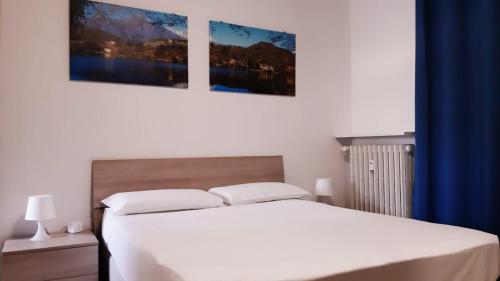 a bedroom with a bed with two pictures on the wall at Apartment "Borgo Olivetti" in Ivrea