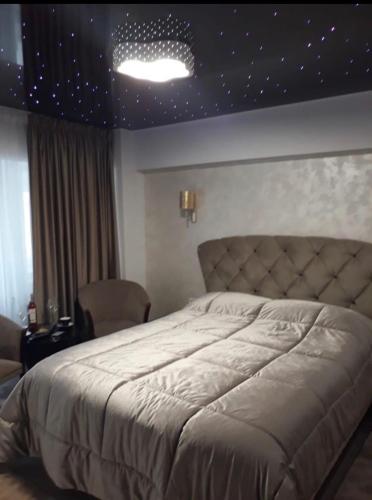 a bedroom with a large bed with stars on the ceiling at Garsoniera lux centru pietonal Tîrgu - Jiu in Târgu Jiu