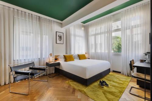 - une chambre avec un lit blanc et un plafond vert dans l'établissement Theodor Brown Rothschild Tel-Aviv, a member of Brown Hotels, à Tel Aviv