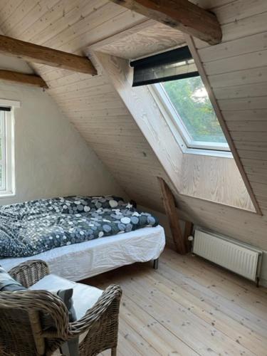 a attic room with a bed and a window at Aabels in Sæby