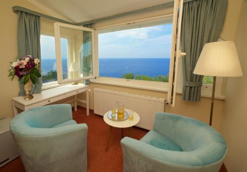 a room with two chairs and a table and a window at Panorama Hotel Lohme in Lohme