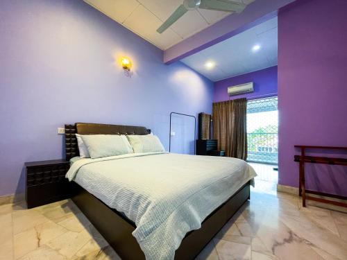a bedroom with purple walls and a large bed at Gather Here 62 5BR Town Center 5 Rooms in Taiping