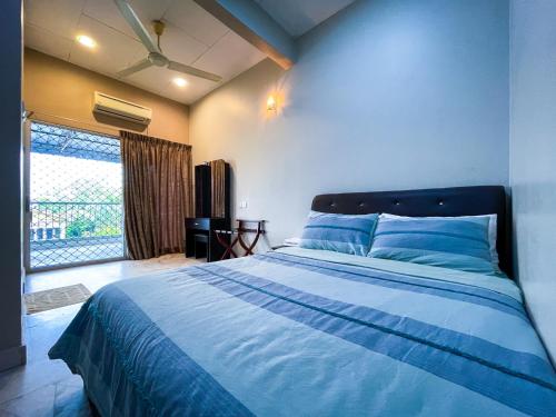 een slaapkamer met een bed met blauwe lakens en een raam bij Gather Here in 62 @ Town Center in Taiping