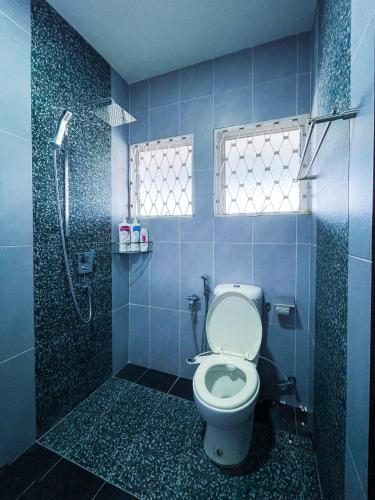 a blue tiled bathroom with a toilet and a shower at Gather Here 62 5BR Town Center 5 Rooms in Taiping