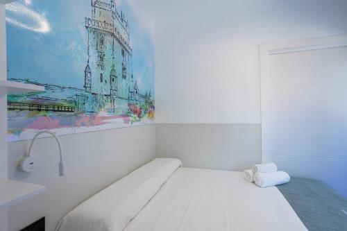 Cette chambre blanche dispose d'un lit et d'une peinture murale. dans l'établissement MUNDOBOOKING Centro Levante, à Benidorm