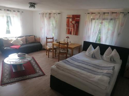 a living room with a bed and a couch and a table at Pension Hofmann in Volkholz