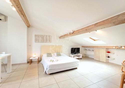 duża biała sypialnia z łóżkiem i stołem w obiekcie Studio Eco-Friendly Commandant André w Cannes