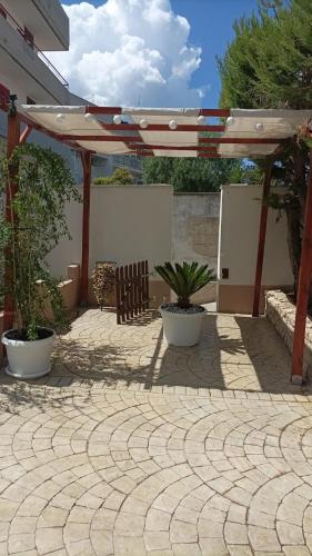 a patio with two potted plants and an umbrella at DOLCE VITA in Bitonto