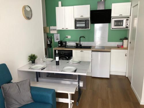 une cuisine avec un comptoir blanc et une chaise bleue dans l'établissement Appart 6 pers rénové en plein cœur de Cauterets, à Cauterets