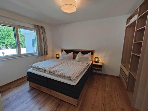 a bedroom with a bed with two lamps and a window at Apartment auf der Schladminger Sonnenseite - smart, zentral & ruhig in Schladming
