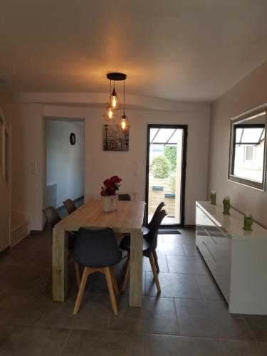 une cuisine et une salle à manger avec une table et des chaises en bois dans l'établissement Le Plaisance, à Ourville-en-Caux