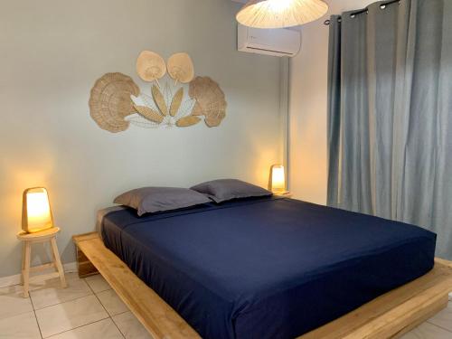a bedroom with a blue bed and two lamps at L’Appart - Les pieds dans l’eau in Sainte-Luce