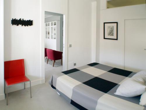 マドリードにあるATOCHA MUSEOSのベッドルーム1室(ベッド1台、赤い椅子付)