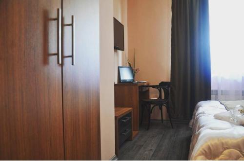 a hotel room with a bed and a desk with a television at Motel Luka in Sarajevo