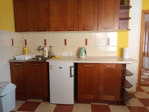 a kitchen with wooden cabinets and a white refrigerator at Apartmán u Anny in Štrba