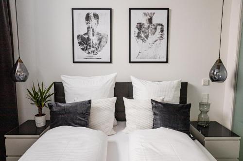 Duas camas num quarto com almofadas pretas e brancas em BONNYSTAY l Modern l Zentral l Work Space l Kitchen l Smart TV l WLAN em Passau