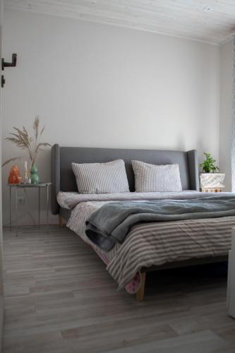 1 dormitorio con 1 cama grande y paredes blancas en Apartamentai Šilutėje en Šilutė