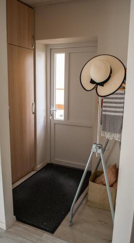 a hat on a tripod in a room with a door at Apartamentai Šilutėje in Šilutė