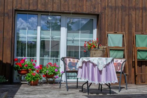 a table and chairs on a patio with flowers at Apartamentai Šilutėje in Šilutė