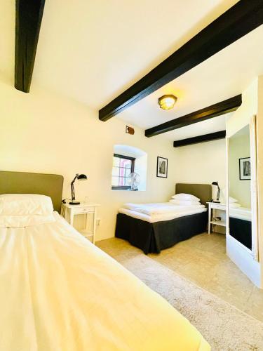 a bedroom with two beds and a mirror at Gårdshotellet in Ystad