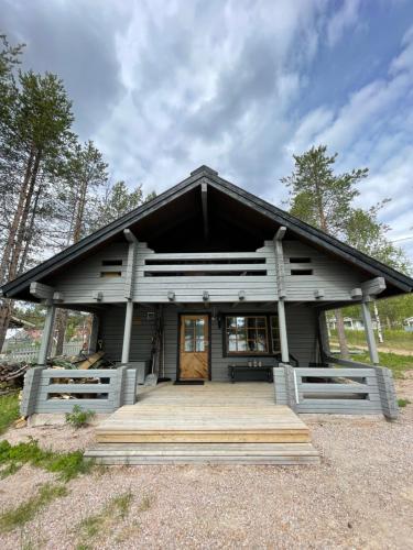 ein kleines Haus mit einer Veranda und einer Holztür in der Unterkunft Siljonranta in Muonio