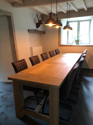 a conference room with a wooden table and chairs at B&B Le Nid d'Hirondelle in Houffalize