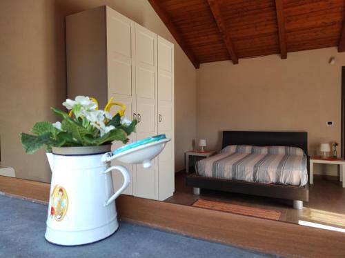 um quarto com um vaso de flores e uma cama em Villa Tenuta ...un oasi di pace em Puntalazzo