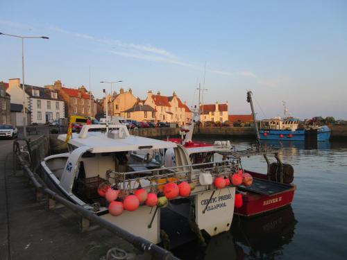 two boats are docked at a dock in the water at Anchor House in Pittenweem
