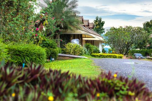 a house with a lot of plants and a driveway at Phukumhom Khao Yai in Wangkata