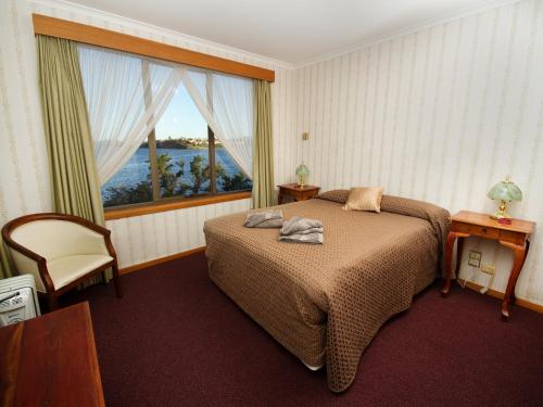 a bedroom with a bed and a large window at Derwent Retreat in Austins Ferry