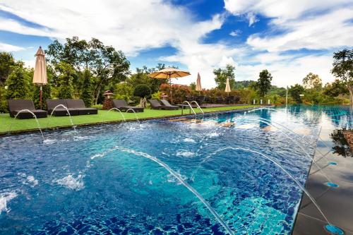 a large swimming pool with blue water in a yard at Phukumhom Khao Yai in Wangkata
