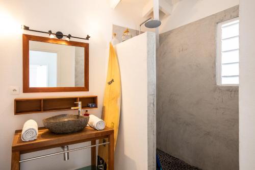 聖馬丁島的住宿－LIFE IS GOOD IN CUL DE SAC，一间带水槽、镜子和冲浪板的浴室