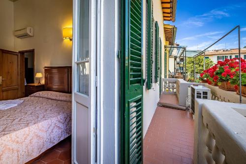 a room with a bed and a balcony with a window at A Casa di Lilli in Florence