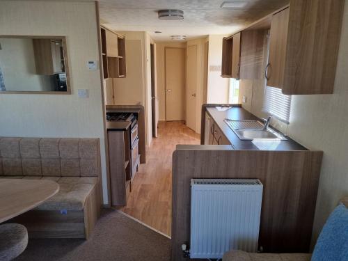 a small kitchen with a sink and a counter at PG49 8 BERTH PET FRIENDLY CARAVAN GOLDEN PALM in Chapel Saint Leonards
