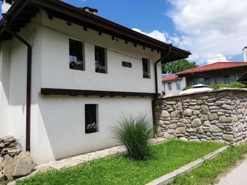 Casa blanca con pared de piedra en Бутикова къща "МЕРИ" en Oreshak