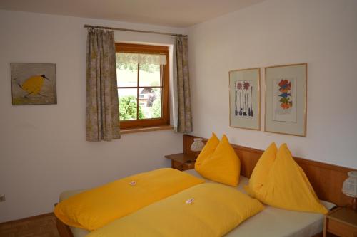 una camera da letto con letto e cuscini gialli di Ferienwohnung Ehrenreich/Pichler a Mariapfarr