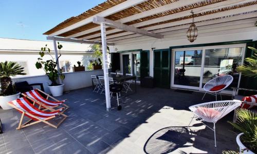 a patio with chairs and a table and awning at Maison Gioffredi in Ischia