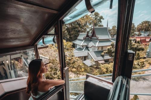 a girl looking out the window of a tram at Thavorn Beach Village Resort & Spa Phuket in Kamala Beach