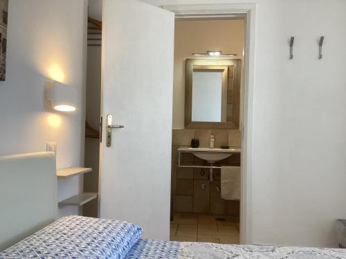 una camera con letto, lavandino e specchio di B&B Casetta Minghitto ad Anacapri