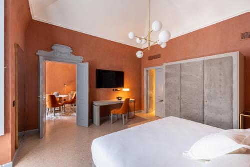 a bedroom with a bed and a desk and a tv at VIS Urban Suites&Spa in Bari