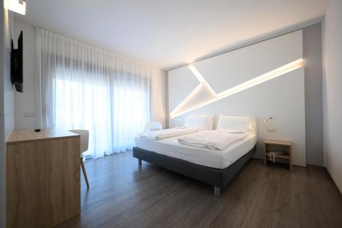 a bedroom with a bed and a large window at Hotel Riviera in Riva del Garda