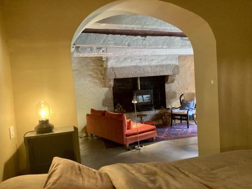 a living room with a fireplace and a couch at Encore une fois, Entre deux in Locmalo