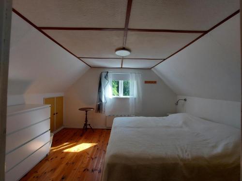 a bedroom with a white bed and a window at Stuga i Ekestad in Kristianstad