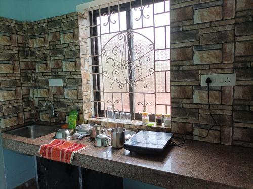 a kitchen counter with a sink and a window at Hakuna Matata Holiday Homes Goa Entire Apartment 1BHK in Baga