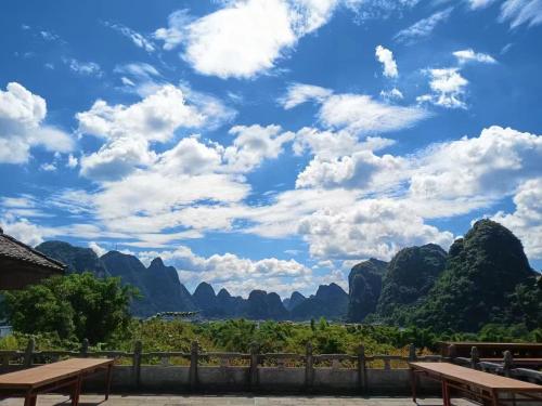een uitzicht op de bergen en de blauwe lucht met wolken bij Riverside Retreat Hotel in Yangshuo