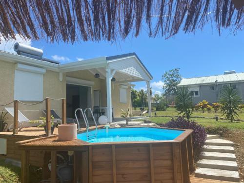 a swimming pool in a yard with a house at Plein Vent in Petit-Bourg